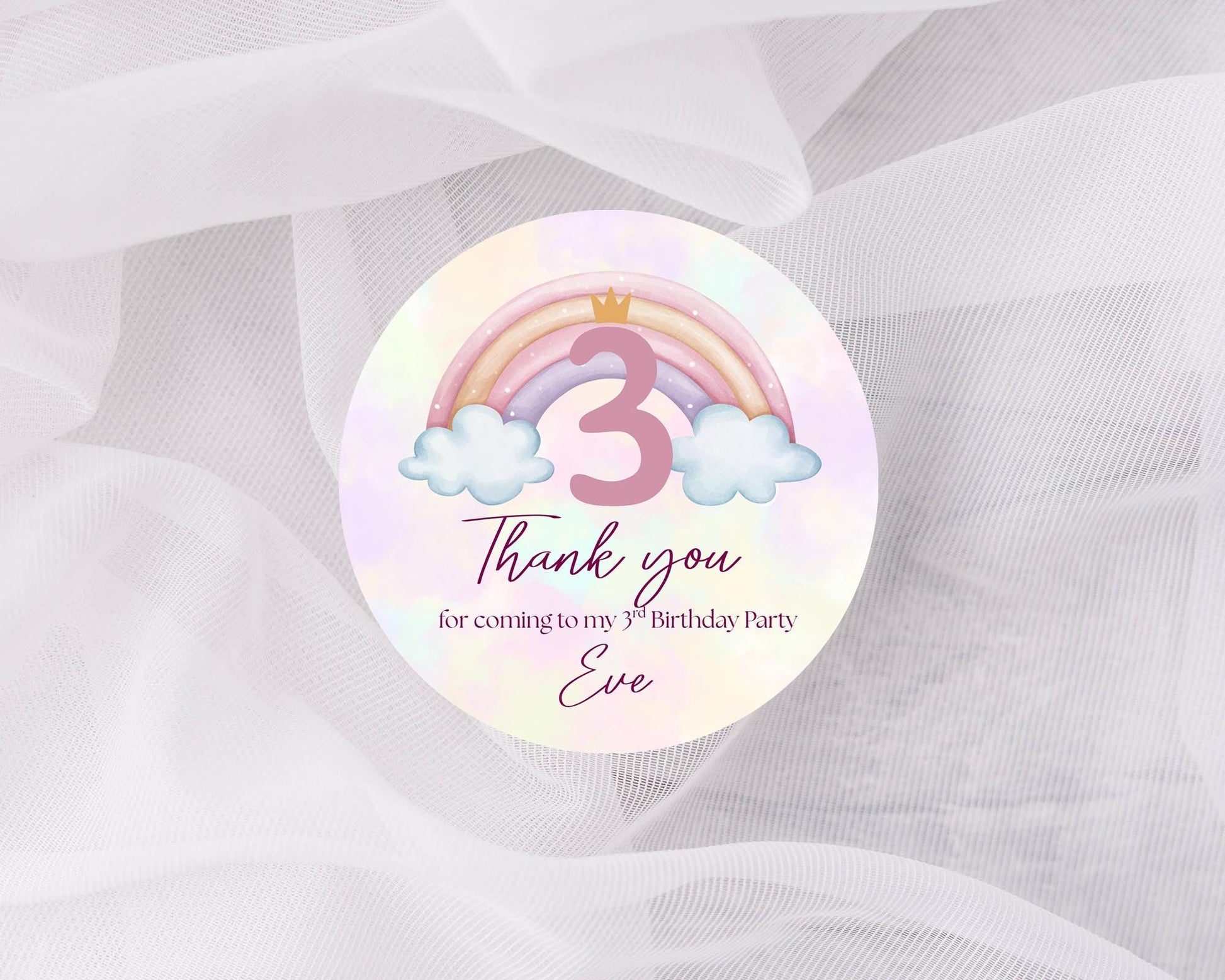 Round sticker with rainbow, number 3, and cloud design on a white background